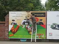 A billboard advertising=billboard, which is lit (lit=yes)