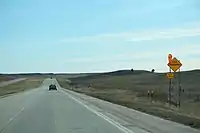 A high winds warning sign in South Dakota, United States(traffic_sign=hazard + hazard=side_winds)