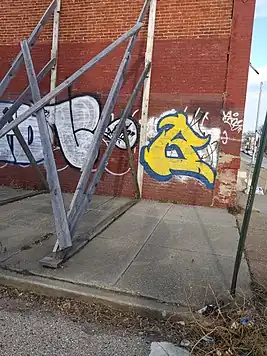 Опорные конструкции, поддерживающие рядный дом, которые загораживают тротуар