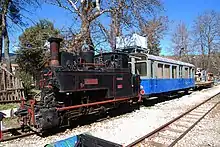 Cail narrow gauge (750&nbsp;mm) steam locomotive ΔΚ-8001 and observation car ΑΒ ΔΚ-121 of the Diakofto-Kalavryta rack railway .