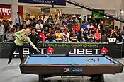 Woman shoots a pool break in mid-air