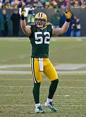 A picture of Clay Matthews in uniform on the field with his hands in the area, presumably to pump up the home-team crowd