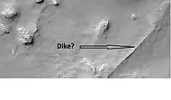 Possible dike in Thaumasia quadrangle, as seen by HiRISE under the HiWish program.  Dikes may have deposited valuable minerals.