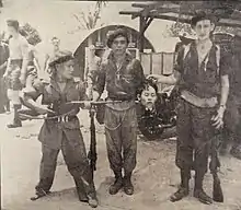 Commonwealth soldiers in a British military base pose with a decapitated head
