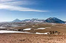 Mountain across a plateau, dwarfing a radio telescope in the foreground