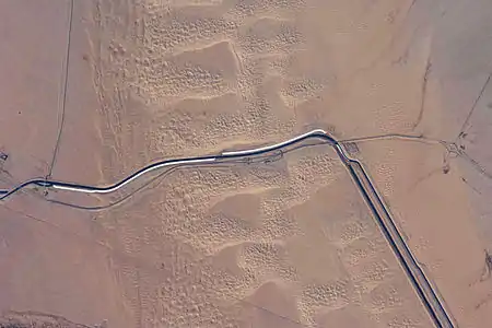 This image captures about 15 kilometers (9.3&nbsp;mi) of the All-American Canal just west of Yuma, Arizona. The photo is taken of the southern section of the Algodones Dunes.