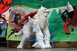 A wolf fursuiter, cosplaying as Amaterasu from Ōkami.