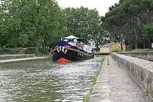 The hotel barge Anjodi crossing the Cesse River on the Canal du Midi.