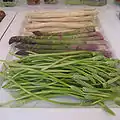 Three types of asparagus are on display, with white asparagus at the back and green asparagus in the middle. The plant at the front is Ornithogalum pyrenaicum, commonly called wild asparagus, and sometimes "Bath asparagus".