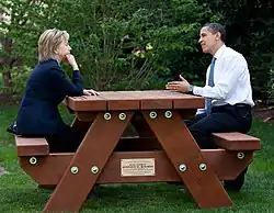 Hillary Clinton and Barack Obama sitting at picnic table in 2009