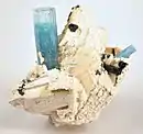 Perched on crystallized, white feldspar is an upright 4&nbsp;cm aquamarine crystal