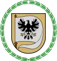 A coat of arms depicting a white flag with a black bird on it with a yellow beak and yellow claws all on a yellow background