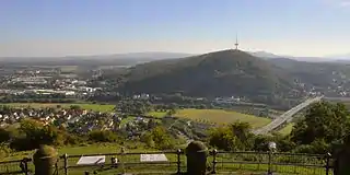 Looking east towards Barkhausen (foreground), the B&nbsp;61 (Portastraße) bridge over the Weser, the Jakobsberg Transmission Tower (Weser Hills) and the villages of Lerbeck (by the wood) and Neesen (left) on the far side of the Weser