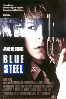 The face of a police officer, holding a revolver up beside her face, her finger on the trigger