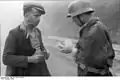 German soldier examining the papers of an Italian civilian outside of Milan (1944)