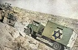 A bulldozer tows a truck on the "Burma road", June 1948