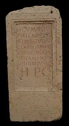 A parallelepiped of stone with a Latin inscription.