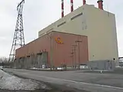 Picture of the generating station taken from route 132. A tall building with an even taller electric pylon on the right.
