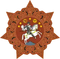 A round orange badge with six points and a horse-mounted man in the centre