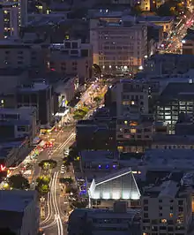 The Hannah Playhouse in the foreground of this night time aerial shot of Wellington's Courtenay Place with the roof lit up as a highlight in the photo..