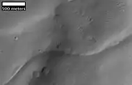 Image from previous photo of a curved ridge that may be an old stream that has become inverted. Illumination is from the NW. Image taken with HiRISE under the HiWish program.