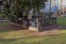 A rectangular area  of about 3 by 7 meters with gravestones fenced in with an cast iron railing about a meter high
