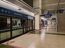 One of the station side platforms, with a platform screen door protecting commuters from the tracks and incoming trains