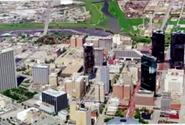 Elevated image showing various buildings in the foreground and middleground with various degrees of broken windows