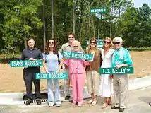 Widow Sherry MacDonald (holding street sign with her husband's name), along with both son Rich and daughter Vicki (behind her), at Dave MacDonald Drive street dedication at housing community developed on the old Augusta International Raceway site in Georgia.  Other racers pictured are Frank Warren (holding his own sign), Pamela Trivette (holding her father's sign), and T J Kelly. 2006