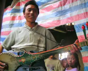 Tibetan man playing a dranyen.