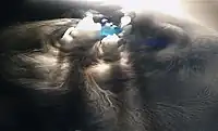 Dry ice pellet subliming in water, releasing thick white fog.