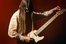 Carlson playing guitar on stage in 2018