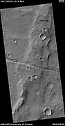 Trough cutting a wrinkle ridge, as seen by HiRISE under HiWish program. Location in the Coprates quadrangle, Mars.