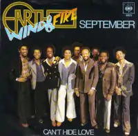 The single sleeve features the musicians standing side-by-side, mostly wearing suits and smiling