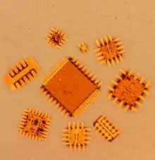 Figure 5. An array of beam leaded silicon integrated circuits showing the attached and extended electroformed beam leads around the perriphery of the silicon chip