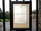 A notice in a frame affixed to a gate