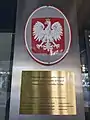 The Coat of arms of Poland in Zagreb. The grey oval plate made of metal sheet is visible. The grey oval plates are popular in schools and embassies on facades, but ovals are considered as ordinary.
