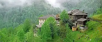 Houses in foggy, tree-covered mountains