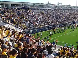 Football fans standing in the bleachers of a stadium