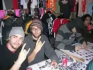 Two band members making the sign of the horns