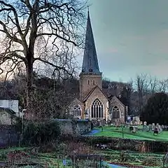 Church with spire beyond a graveyard