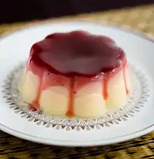 Griesmeelpudding met rode bessensaus&nbsp;[nl] is semolina pudding served with red currant sauce.
