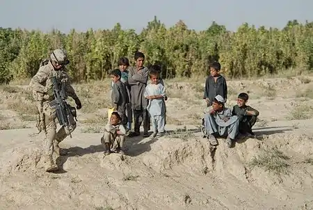 Guard in Afghanistan passing group of kids