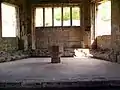 Interior of chapter house, octagonal font from church in centre.