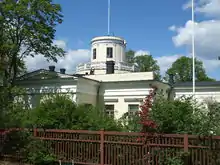 An astronomical observatory surrounded by greenery and trees.