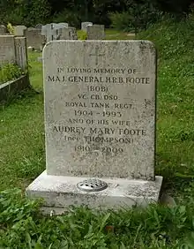 A granite headstone among other headstones