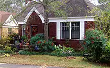A small, one-story brick-faced house with a small yard in front. This house is located in Little Rock, Arkansas.