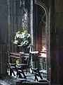 Candles burning in front of a statue of St Winefride