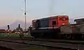 BB 200-03 locomotive waiting for departure signal at the station. Mount Merapi is visible at the background, while Mount Merbabu is hindered by the locomotive