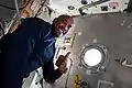 A smiling Glover poses next to a hatch in Node 1